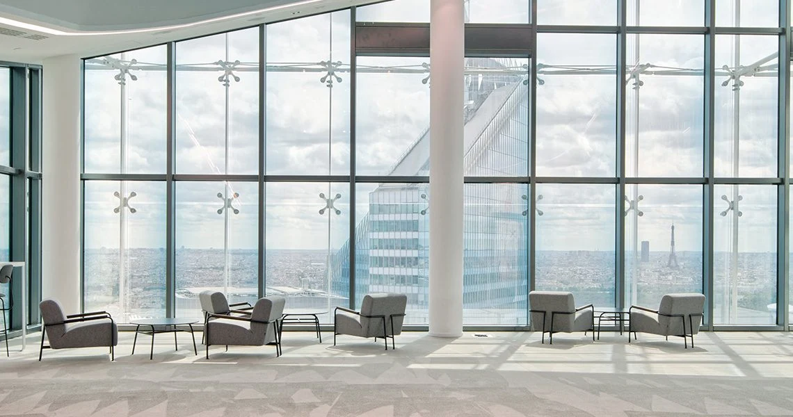 Ambiente do escritório da Saint-Gobain em Paris, com janelas panorâmicas e vista da cidade